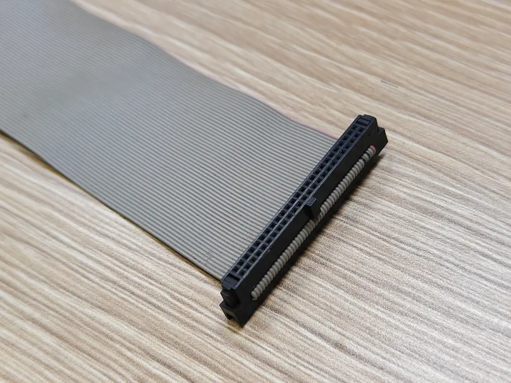 Angled close-up of a ribbon connector with the cable entry and red edge stripe visible