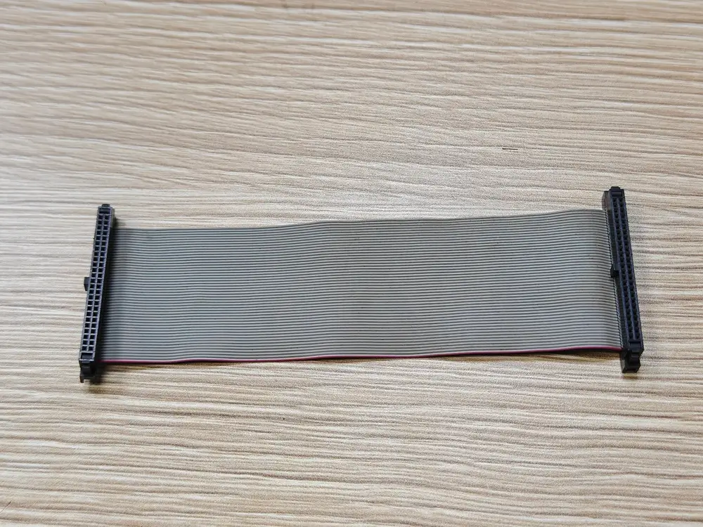 Grey flat ribbon cable with a red edge stripe and black connectors at both ends